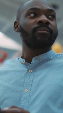 Mavi tişört giyen bir adam dinamik ve çekici bir ortamda çalışırken kararlılık sergiliyor.