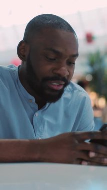 Yoğunlaşmış bir adam yoğun bir ortamda akıllı telefonunu kullanarak modern bağlantıyı vurguluyor.