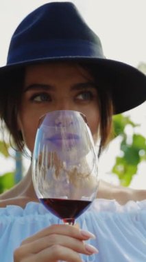 Şık ve şık bir kadın, büyüleyici bir üzüm bağında kırmızı şarap yudumlayarak saf karmaşıklık yaymaktan hoşlanır.