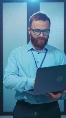 Odaklanmış ve kendini işine adamış bir profesyonel modern, teknolojik çalışma ortamında dizüstü bilgisayarıyla derinden ilgilenir.