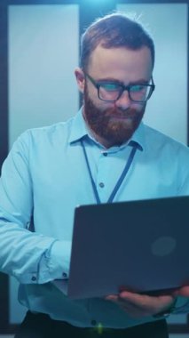 Çok yetenekli bir bilişim uzmanı, modern ve gelişmiş bir veri merkezinde aktif olarak dizüstü bilgisayar kullanıyor.