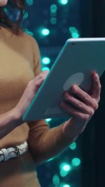 Bir kişinin tablet cihazıyla çok şık ve modern bir ortamda aktif olarak etkileşime geçtiği detaylı bir yakın çekim görüntüsü.