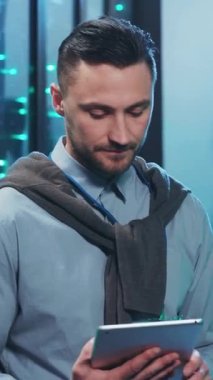 Bir adam, modern ve çağdaş bir ofis ortamındayken tablet cihazına derinden konsantre olmuştu.