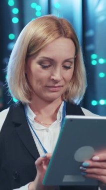 Odaklanmış bir kadın profesyonel modern yüksek teknolojili çalışma ortamında bir tabletle derinden ilgilenir.