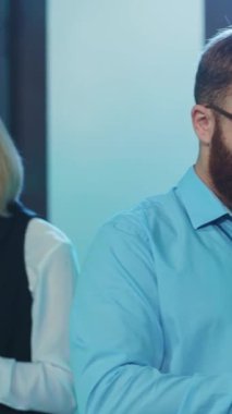 Sakal ve gözlük takan kendini işine adamış ve profesyonel bir kişi şık bir ofiste çalışıyor.