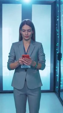 Son derece profesyonel bir kadın, modern iş dünyasının canlı dinamiklerini gösteren akıllı telefonuyla aktif olarak meşgul.