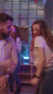 Canlı ve canlı bir dans sahnesinde renkli bir ortamda müzik dinleyerek harika vakit geçiren genç bir kadın var.