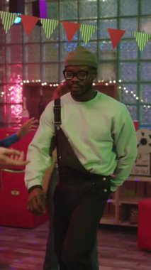 Şık bir dansçı renkli pankartlar ve ışıklarla dolu canlı ve şenlikli bir atmosferde etkileyici hareketler sergiler.