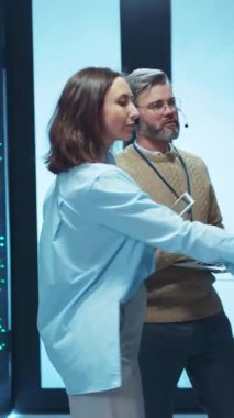 İki yetenekli profesyonel modern ofis çalışma alanında gelişmiş dijital cihazlarla uğraşıyorlar.