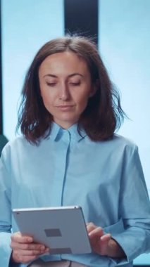 Genç bir profesyonel, modern ve yenilikçi bir çalışma alanında yaratıcılık ve üretkenliği yansıtan bir tablet kullanıyor.