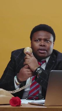 Bir iş adamı klasik bir telefon kullanarak aktif olarak bir iş görüşmesine katılır, profesyonellik ve derin bir odak noktası gösterir.