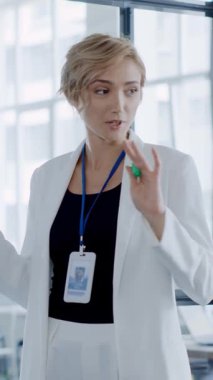 Şık bir spor ceket giyen kendine güvenen bir iş kadını modern bir ofis ortamında verimliliğe ilham veriyor.