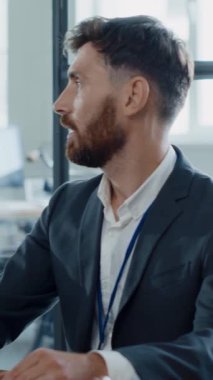 Kendini işine adamış ve odaklanmış bir profesyonel adam modern ofis ortamında özenle çalışıyor.