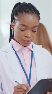 Kendini işine adamış ve tutkulu bir kadın doktor elinde notlarla dolu bir not panosuyla önemli bir işe dalmış durumda.