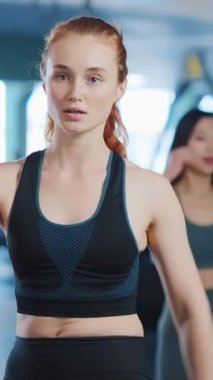 Kararlı genç bir kadın modern bir spor salonunda çalışıyor. Bağlılığını ve kendini spora adamış.