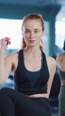 Formda bir kadın gücünü ve kararlılığını modern, kuytu bir spor salonunda çalışırken gösterir.