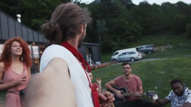 Ortadaki adam gibi bir hippiyle dışarıda selfie çeken neşeli arkadaşlar. Mutlu anılar, modern teknolojiler, eğlenmek. Parti zamanı, dinlenme, takılma.