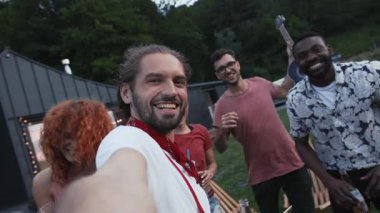 Çok ırklı bir grup arkadaş içkilerini yudumlar ve akşamları dışarıda selfie çekerler. Neşeli ruh hali, olumlu duygular, gerçek arkadaşlık. Birlikte mutluyuz.