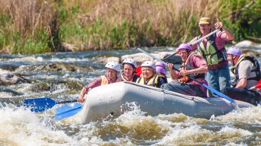 Myhiya, Ukrayna - 1 Mayıs 2018: Rafting. Neşeli grup yaşlı insan bir lastik şişme tekne yelken. Ekip çalışması. Aşırı spor. Ekolojik su turizm. Olumlu duygular, adrenalin