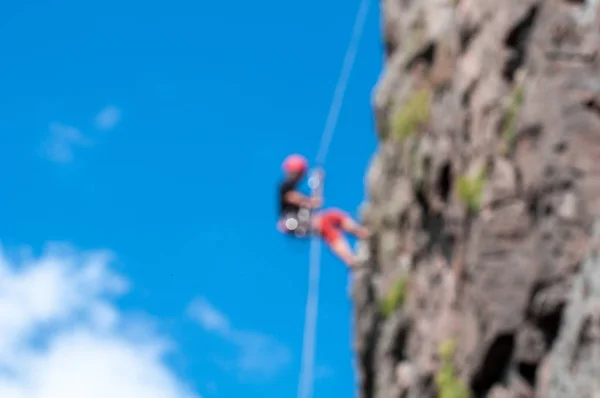 Rock Climbing Blurred Figure Climber Vertical Rock Fuzzy Colorful Bokeh — Stock Photo, Image