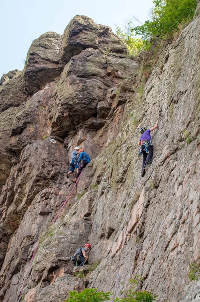 Yuzhnoukrainsk, Ukrayna - 20 Haziran 2018: dağcılık. Bir grup genç kaya dağcılar dikey granit kayaya tırmanmak. Aşırı spor. Eğitim dağcıların
