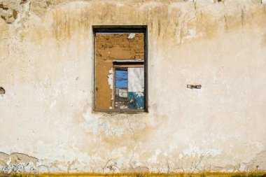 Çatı olmadan eski bir toprak evin kalıntıları. Pencereler ve kapılar yerinde duvarda delikler.