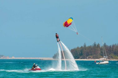Hainan, Sanya, Çin - 14 Mayıs 2019: Flyboarding. Güçlü bir su jetiyle tahtanın üzerinde suyun üzerinde uçuyor. Sahilde cazibe. Ekstrem spor ve rekreasyon.