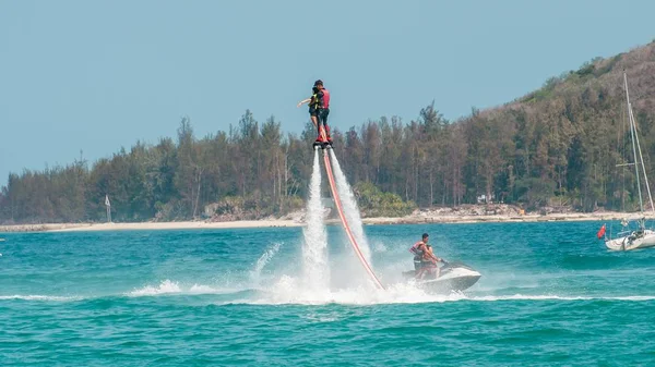 海南、サンヤ、中国 - 2019年5月14日:フライボード。水の強力なジェットでボード上の水の上を飛ぶ。ビーチのアトラクション。極端なスポーツとレクリエーション. — ストック写真
