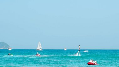 Hainan, Sanya, Çin - 14 Mayıs 2019: Flyboarding. Güçlü bir su jetiyle tahtanın üzerinde suyun üzerinde uçuyor. Sahilde cazibe. Ekstrem spor ve rekreasyon.