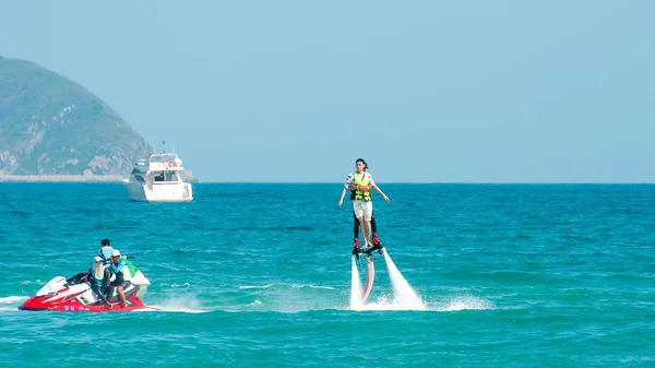 海南、サンヤ、中国 - 2019年5月14日:フライボード。水の強力なジェットでボード上の水の上を飛ぶ。ビーチのアトラクション。極端なスポーツとレクリエーション. — ストック写真