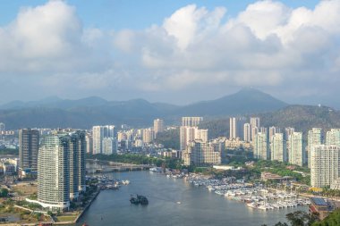 Sanya kentinin ilçelerinden birinin manzarası. Görünür gökdelenler ve kamu feribot terminali vardır. Hainan Island, Çin.