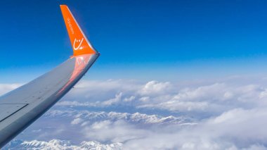 Kazakistan - 10 Mayıs 2019: Tien Shan'ın kuzeybatısında bir dağ sırası olan Zaili Alatau'dan manzara. Ukrayna havayolu Şirketi Skyup'ın uçağı. Uçağın kanadındaki yazıt skyup.aero.