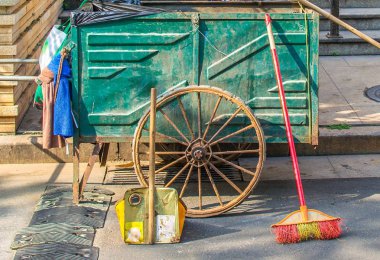 Sokakta çöp toplama araçları - süpürge, vagon, kepçe.