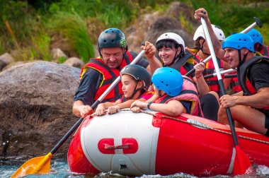 Myhia, Ukrayna - 17 Ağustos 2019: Rafting. Erkek ve kadın neşeli bir grup nehir üzerinde büyük bir şişme tekne üzerinde iner. Teknede bir çocuk var. Mutlu insanların samimi duyguları.