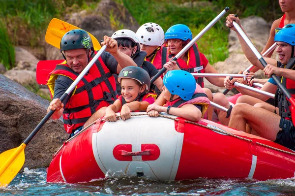 Myhia, Ukraina-17 augusti 2019: rafting. En glad grupp av män och kvinnor stiger ned på en stor uppblåsbar båt på floden. Det finns ett barn i båten. Uppriktiga känslor av lyckliga människor. — Stockfoto