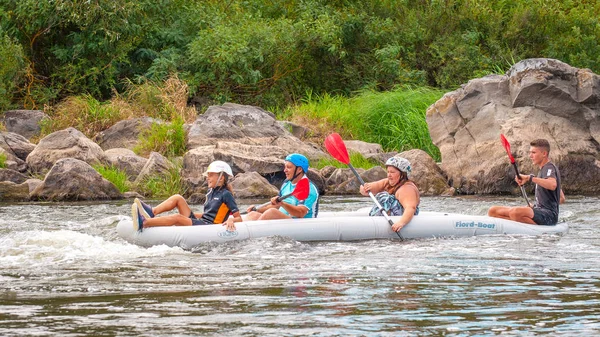 Myhia, Ukraine - 17 août 2019 : Rafting. Une famille amicale joyeuse avec un enfant rafting dans un bateau gonflable en caoutchouc sur les rapides d'une rivière rapide. Le concept d'une famille heureuse, un mode de vie sain . — Photo