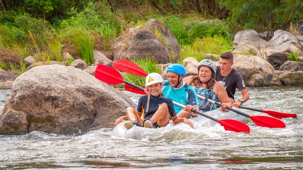 Myhia, Ukraine - August 17, 2019: Rafting. A cheerful friendly family with a child rafting in a rubber inflatable boat on the rapids of a fast river. The concept of a happy family, healthy lifestyle. — Stock Photo, Image