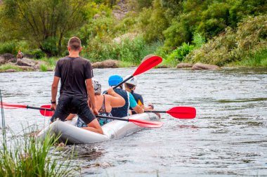 Myhia, Ukrayna - 17 Ağustos 2019: Rafting. Bir çocuk ile neşeli bir dost aile nehir boyunca bir lastik şişme tekne rafting olduğunu. Mutlu bir aile kavramı, sağlıklı yaşam tarzı.