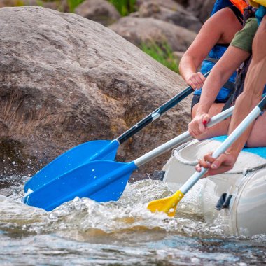 Rafting gezisi. Su sıçramaları ile kürek yakından görünümü. Kürekçiler çalkantılı nehrin üstesinden gelmek için çaba gösterirler. Takım çalışması kavramı, sağlıklı yaşam tarzı.