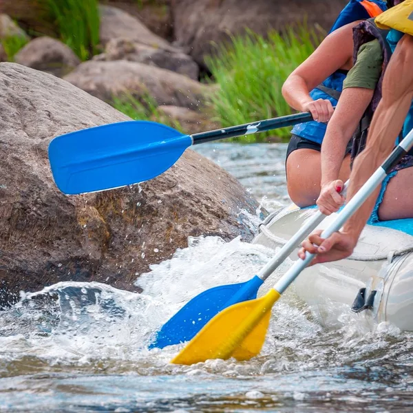 Gita di rafting. Vista da vicino dei remi con spruzzi d'acqua. I vogatori fanno uno sforzo per superare il fiume turbolento. Il concetto di lavoro di squadra, stile di vita sano . — Foto Stock