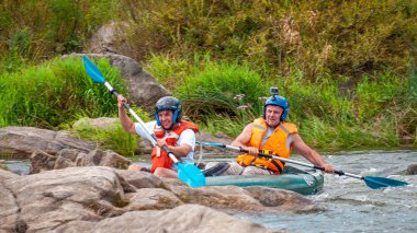 Myhiya, Ukrayna - 17 Ağustos 2019: Rafting gezisi. İki kürekçi lastik şişme botla nehirde rafting yapıyorsun. Nesillerin iletişim kavramı, yaşlıların fiziksel aktivitesi.