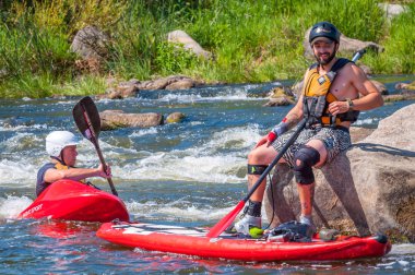 Myhiya, Ukrayna - 17 Ağustos 2019: Whitewater'da antrenman sırasında kayakçılar. Şişme kürek kurulu Sup ayağa adam.