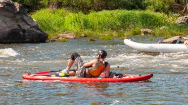 Myhiya, Ukrayna - 17 Ağustos 2019: Whitewater'da antrenman sırasında kayakçılar. Şişme kürek kurulu Sup ayağa adam.