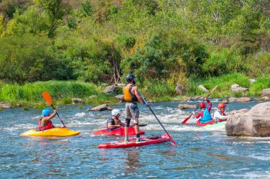 Myhiya, Ukrayna - 17 Ağustos 2019: Whitewater'da antrenman sırasında kayakçılar. Şişme kürek kurulu Sup ayağa adam.