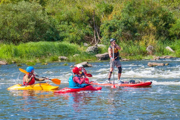 Myhiya, Ucrania - 17 de agosto de 2019: Atletas kayakistas durante el entrenamiento en aguas bravas. Hombre en inflable stand up paddle board SUP . — Foto de Stock