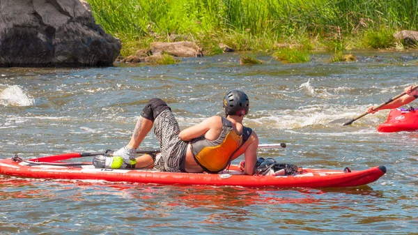 Myhiya, Ucrânia - 17 de agosto de 2019: Athletes kayakers during training on whitewater. O homem na placa de remo inflável levanta-se SUP . — Fotografia de Stock