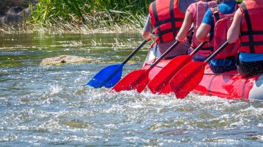 Rafting gezisi. Su sıçramaları ile kürek yakından görünümü. Kürekçiler çalkantılı nehrin üstesinden gelmek için çaba gösterirler. Takım çalışması kavramı, sağlıklı yaşam tarzı.