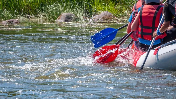Rafting gezisi. Su sıçramaları ile kürek yakından görünümü. Kürekçiler çalkantılı nehrin üstesinden gelmek için çaba gösterirler. Takım çalışması kavramı, sağlıklı yaşam tarzı.