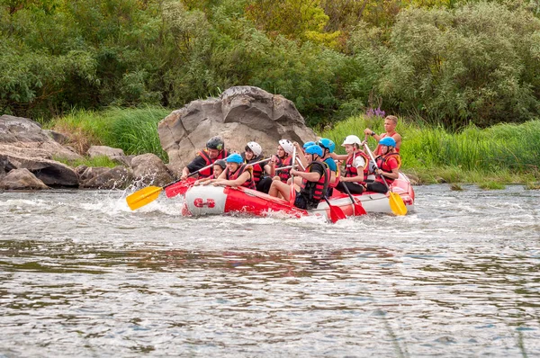 Myhia, Ucrânia - 17 de agosto de 2019: Rafting. Um grupo alegre dos homens e das mulheres desce em um barco inflável grande no rio. Há uma criança no barco. Emoções sinceras de pessoas felizes . — Fotografia de Stock