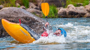 Myhiya, Ukrayna - 17 Ağustos 2019: Playboating. Elinde küreklerle kayıkta oturan bir adam su üzerinde egzersiz yapar. Whitewater üzerinde serbest kayak. Eskimo rulo.